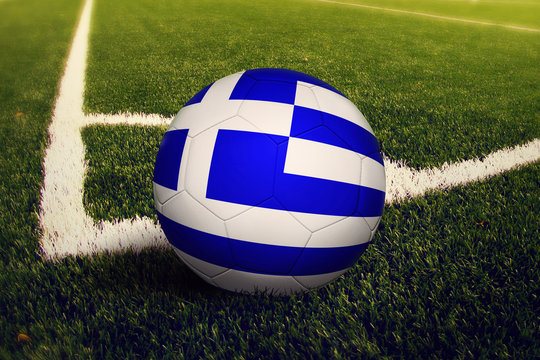 Greece ball on corner kick position, soccer field background. National football theme on green grass.