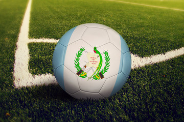 Guatemala ball on corner kick position, soccer field background. National football theme on green...