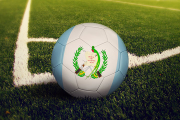 Guatemala ball on corner kick position, soccer field background. National football theme on green grass.