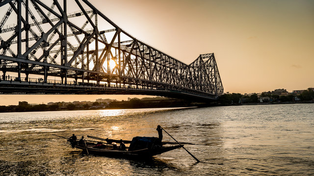 Silhouette of Howrah Bridge at the time of Sunrise. Howrah Bridge is a bridge with a suspended span over the Hooghly River in West Bengal. - Powered by Adobe