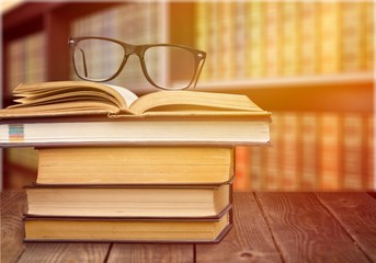 Collection of old books  and glasses on background