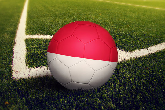 Indonesia ball on corner kick position, soccer field background. National football theme on green grass.