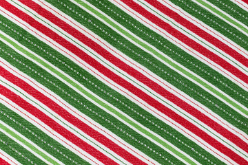 Christmas coloured cloth textured red, white and green striped background 