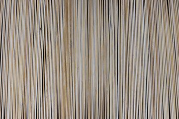 Wooden bamboo skewers set on a black backdrop for background purposes. Texture, natural