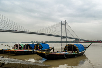 Vidyasagar Setu bridge with  wooden boat on Hoogly river.