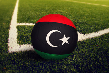 Libya ball on corner kick position, soccer field background. National football theme on green grass.