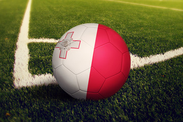 Malta ball on corner kick position, soccer field background. National football theme on green grass.