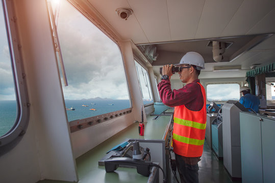 pilot control or port controller, harbor master, duty officer handle of the ship navigating to the port destination, keep watching navigation on the bridge of the ship vessel under voyage sailing 