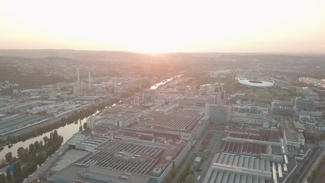 Aerial drone shot of beautiful Stuttgart, Germany while sunset with the Mercedes Benz Arena, the famous Volksfest Wasen and a lot of industry in the foreground and Stuttgart Downtown in the background