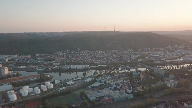 Aerial drone shot overviewing the Neckar Valley as well as the important port of Stuttgart, Germany while sunset