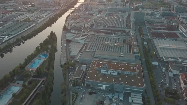 Aerial drone shot of beautiful Stuttgart, Germany while sunset with the Mercedes Benz Arena, the famous Volksfest Wasen and a lot of industry in the foreground and Stuttgart Downtown in the background