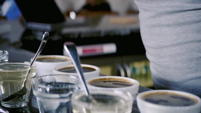 Coffee roaster cupping (tasting) freshly roasted coffee beans