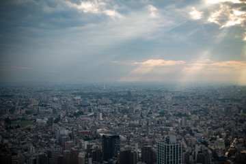 雲間から光が差し込む東京の市街地