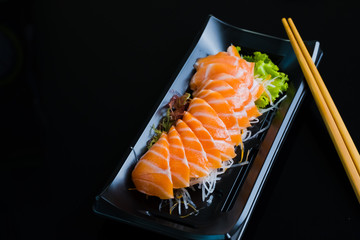 Salmon Sashimi on Black Ceramic Plat,black background.