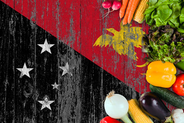 Fresh vegetables from Papua New Guinea on table. Cooking concept on wooden flag background.