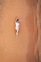 Obraz premium woman lying on sand, from above
