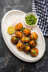 Tandoori aloo are roasted potatoes with Indian spices. It's a party appetiser served with green chutney. selective focus