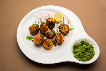 Tandoori aloo are roasted potatoes with Indian spices. It's a party appetiser served with green chutney. selective focus