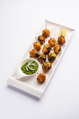 Tandoori aloo are roasted potatoes with Indian spices. It's a party appetiser served with green chutney. selective focus