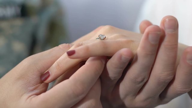 Soldier putting ring on female hand, proposing to girlfriend, couple marriage