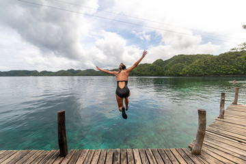 Fototapeta na wymiar Woman jumping into the sea at Socorro, Surigao del Norte