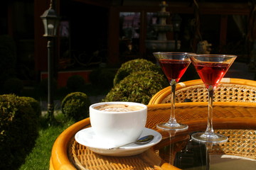 cup of coffee with cream and two glasses with liqueur