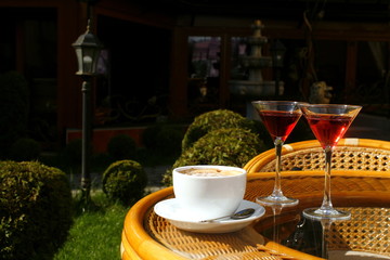 cup of coffee with cream and two glasses with liqueur