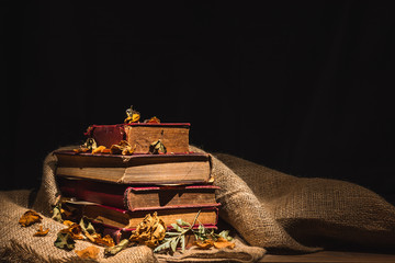 pile of old books and dry flower on sackcloth, still life photography