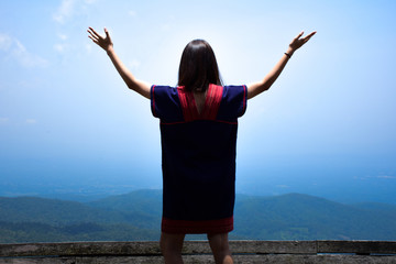 Women stand arms, breathe fresh air and watch beautiful nature.