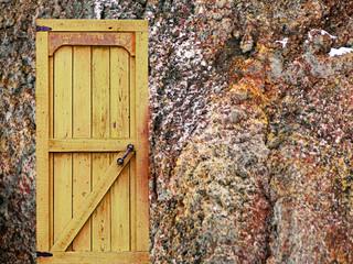 Retro wooden door in stone castle wall.
