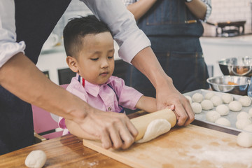 Fototapeta premium happy family in kitchen. family knead dough and bake the bakery together in kitchen