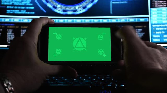 Hackers hands using a smartphone (landscape) in dark office, motion-tracked for easy screen replacement