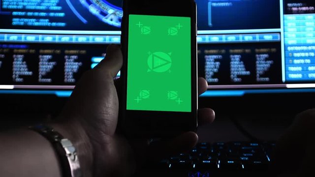 Hacker using a smartphone in front of hi-tech screens, motion-tracked for easy screen replacement