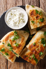 Bolani is a traditional Afghani flatbread stuffed and baked with either potato, onion, cilantro filling closeup. Vertical top view