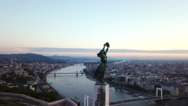 Aerial footage by the liberty statue of Budapest, Hungary, with a general view the city during early morning light.