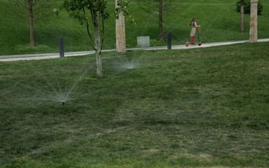 Garden Lawn automatic sprinkler in action water the grass in the park