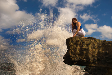 oung attractive and concentrated woman practicing yoga meditation exercise smiling happy and relaxed at beautiful beach rock cliff in healthy natural lifestyle