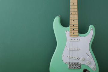 Obraz premium 緑色の背景に置いたパステル緑色のエレキギターストラトキャスター
