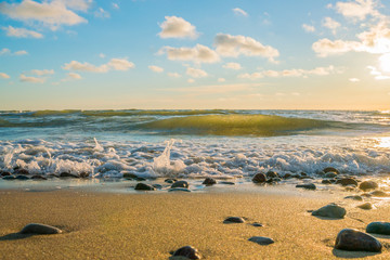 Very beautiful view of the sea coast at sunset. The Baltic Sea is washed by a sea wave.