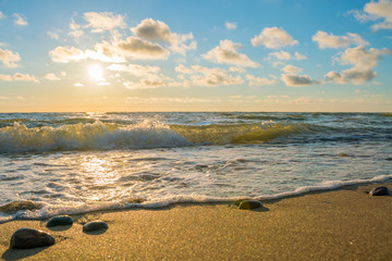 Very beautiful view of the sea coast at sunset. The Baltic Sea is washed by a sea wave.
