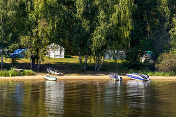 Naklejka premium Hiking camp on the river bank. Tourism and outdoor recreation in the forest on the banks of the river. Ecology.
