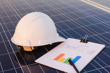 Engineers are examining the performance graph of energy production from solar panels that are...