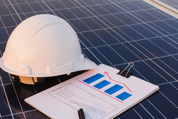 Engineers are examining the performance graph of energy production from solar panels that are...