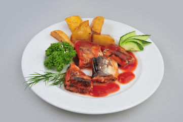 Plate with sardines tomatoes and aromatic herbs on gray isolated background