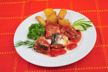 Plate with sardines tomatoes and aromatic herbs on a table
