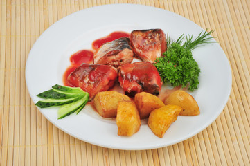 Plate with sardines tomatoes and aromatic herbs on a table