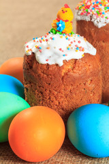 Easter cake and painted eggs on a plate with sackcloth on the background.