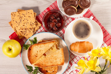 Toasted slices of bread with cheese, apple, cookies and cup of coffee.