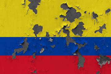 Close up grungy, damaged and weathered Colombia flag on wall peeling off paint to see inside surface.