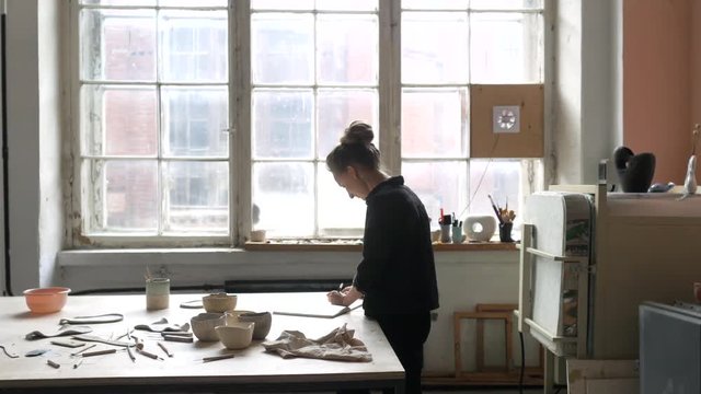 stylish woman ceramist draws a mock designer ceramics